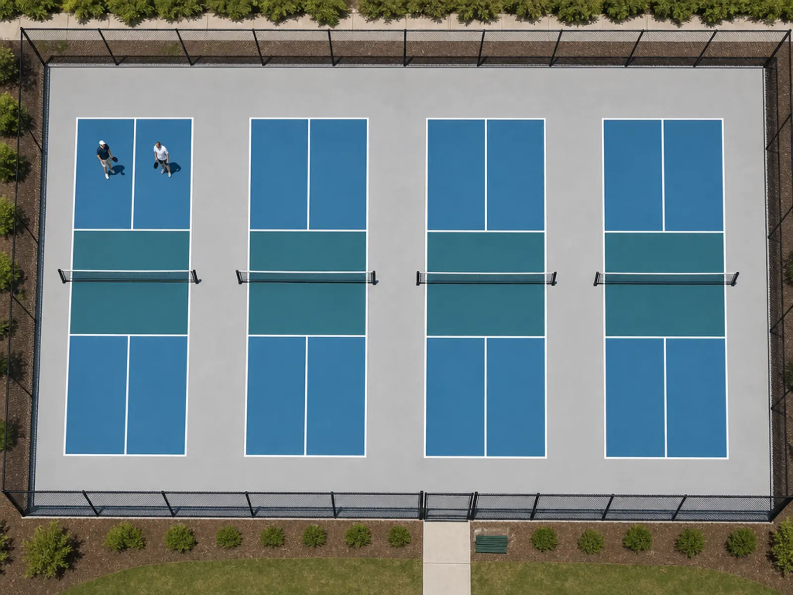 Overhead view of four adjacent blue pickleball courts